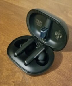 The Poly Voyager Free 60+ UC earbuds in their opened case. 