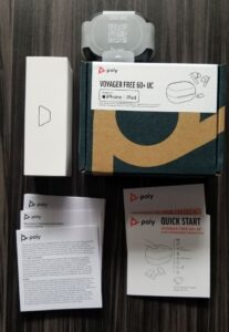 The contents of the The Poly Voyager Free 60+ box, including cables, earbuds and docs.